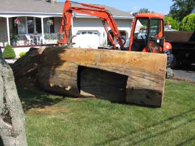 Photo of old underground storage tank in front of forklift truck being removed from front lawn of residential property.
