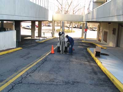 Photo of Statewide Environmental Services technician drilling through concrete to test soil on commercial property.
