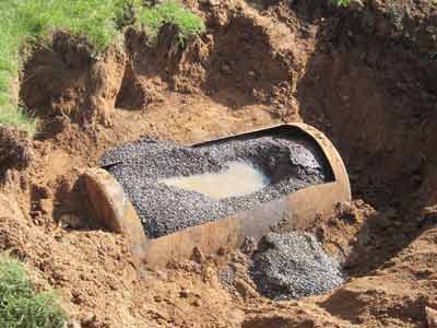 Photo of abandoned oil tank that has been cleaned and filled in place with inert material before the oil tank grave is filled in.